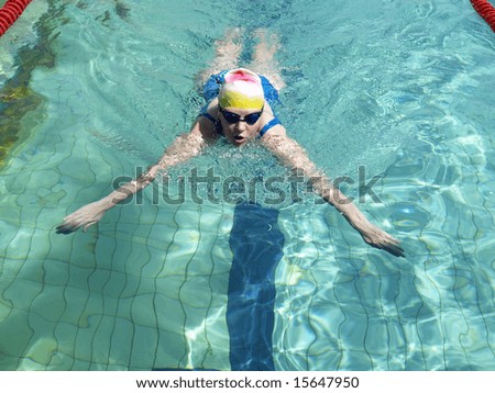 Swimming woman performing breaststroke with inhale