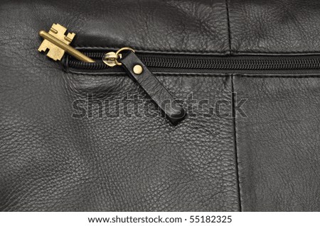 Leather item background with yellow metal key in a pocket