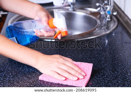Cleaning kitchen with spray and sponge