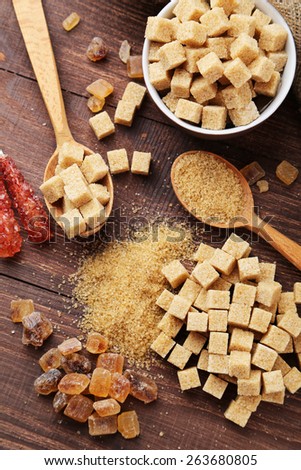 Various kinds of sugar on brown wooden background