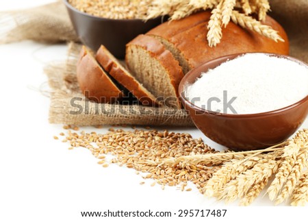 Ears of wheat and bowl of flour on white background