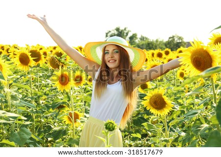Beautiful girl with hat in the sunflowers field