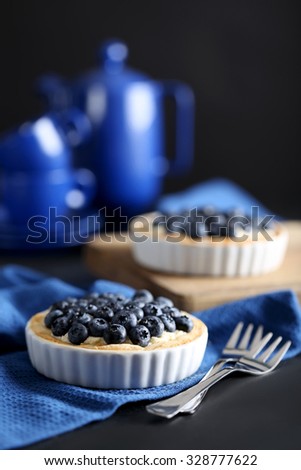 Homemade blueberry tart on black wooden table