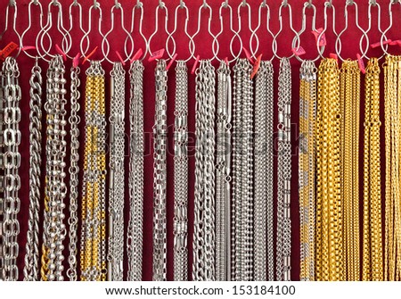 Row of the necklace,White and yellow gold chains isolated on pink background,Hanging necklaces.
