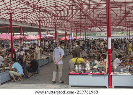 BEIJING, CHINA - AUGUST 23, 2014: People visiting and buying articles at the Panjiayuan market