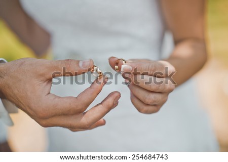 Wedding rings in hands of the newly-married couple.