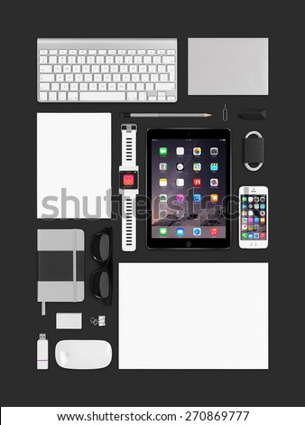 Varna, Bulgaria - February 10, 2015: Top view of branding identity technology Apple products mockup. Consists of ipad air 2, smart watch, iphone 5s, keyboard, notebook, magic mouse, flash drive, paper