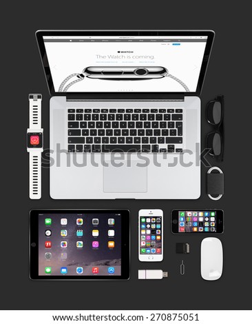 Varna, Bulgaria - February 09, 2015: Top view of Apple gadgets technology mockup consisting macbook pro with apple watch web page on the screen, ipad air 2, smart watch concept, iphone 5s, magic mouse