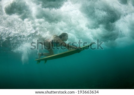 the girl dives under a wave. duck dive