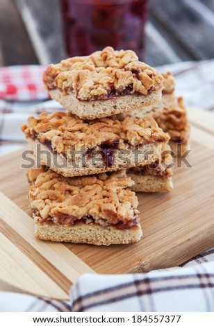 Homemade jam filled bar cookies on wooden board