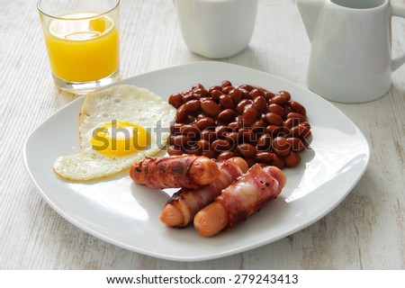 Full English cooked breakfast with bacon, sausage, fried egg and baked beans