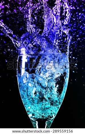 wine glass and splash colored water blue