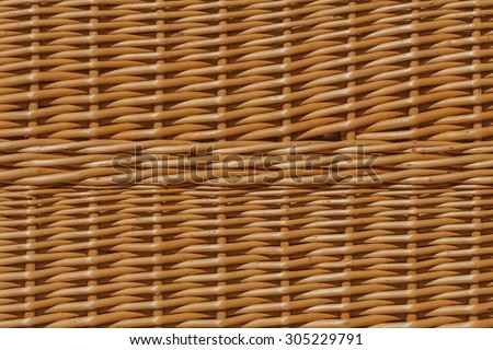 Background of wicker, wicker piece of braid. An example of manual work. Warm colors of lighting.