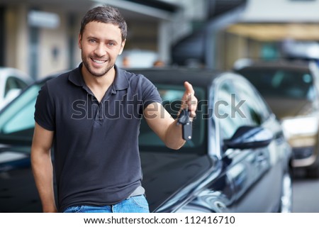 Young man with the keys at the car