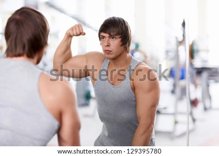 Athletic man in the mirror at the gym