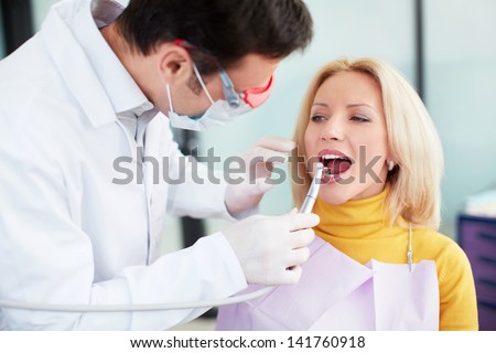 Stomatolog treats teeth patient in clinic Stockfoto © 