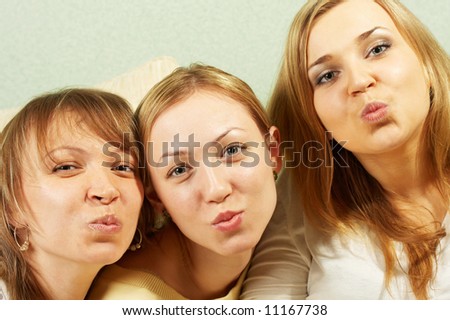 Three charming girls send an air kiss to the camera