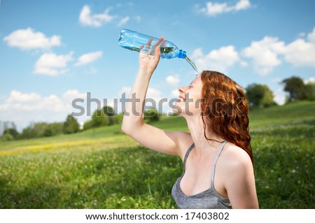 The girl in park pours over a face cold water