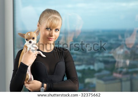 The elegant young woman at a window with the tiny doggie on hands