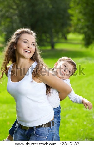 Cheerful mother and son play a summer garden