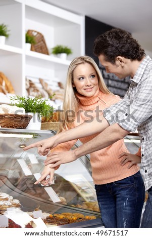 The young people buy bread in shop