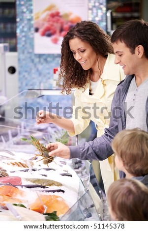 The family in shop at seafood chooses meal