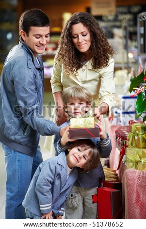 Happy family with boxes of gifts in shop