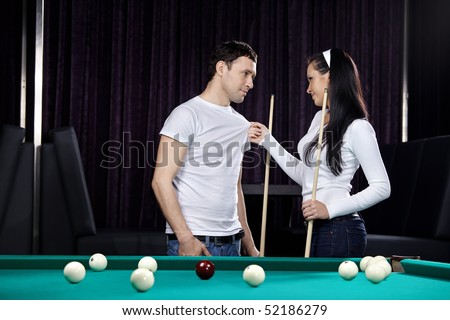 Young attractive couple near to a billiard table