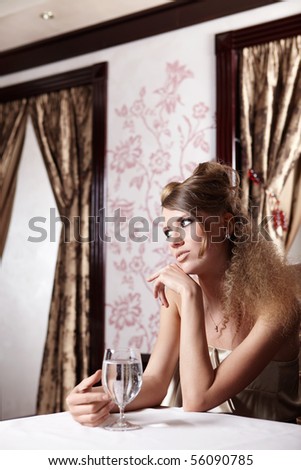 The lovely young girl waits for someone in cafe