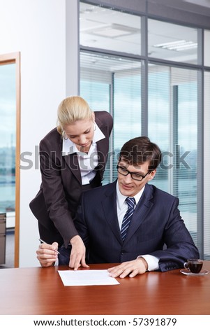 Girl shows the boss where to put the signature