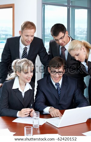 Business people looking at laptop in office