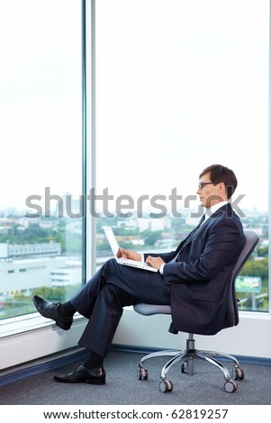 Businessman with laptop on the background of a large window