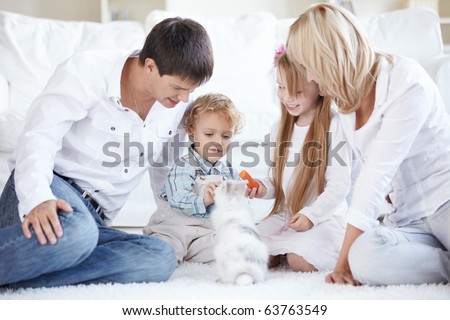 A happy family with children feeding a pet