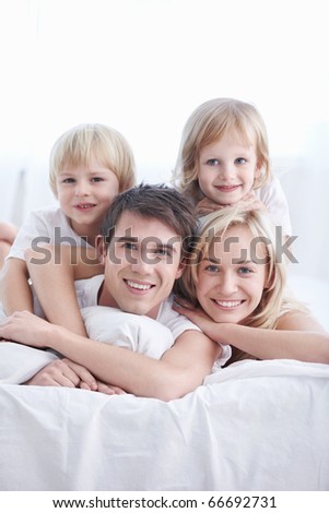 A happy family with two children in the bedroom