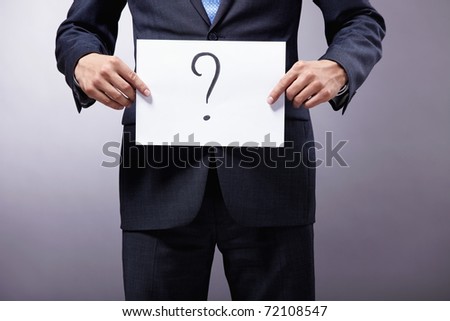 A man holding a sign with a question mark