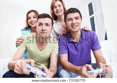 Young  friends play video games at home