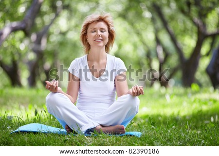Mature woman in a park yoga