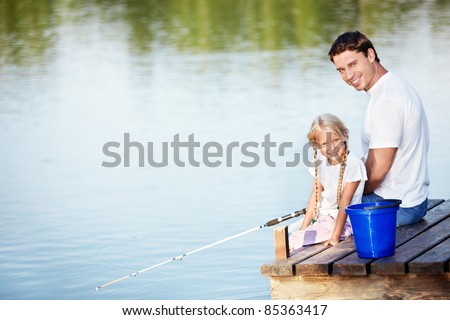 Father and daughter go fishing on the lake