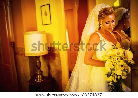 Bride in white wedding dress at a mirror