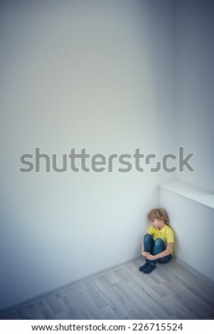 Little boy in corner of the room