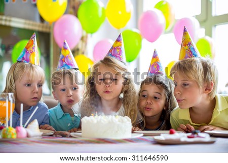 Children blow out the candles on the cake