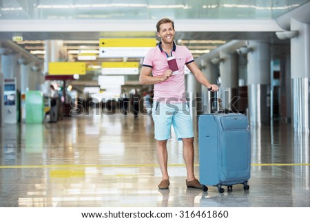 Happy man with a suitcase at the airport