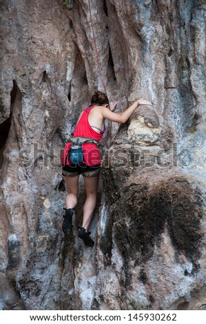Woman climbing on the rock route summer (Railay Beach, Krabi province Thailand).