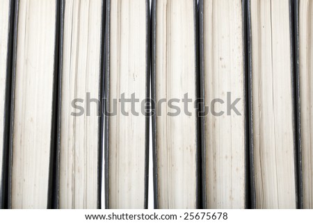 Close-up of a row of old marked antique books, leather-bound with white background light through the gaps between books