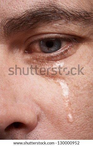 Crying man with tears in eye closeup