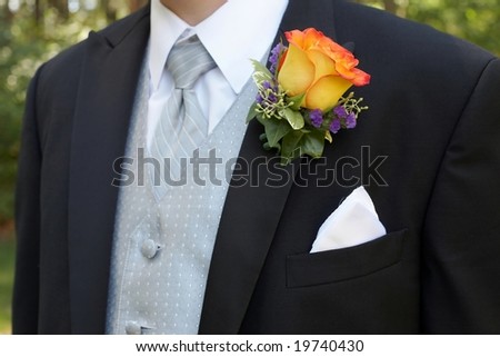 Orange rose wedding boutonniere on suit of groom