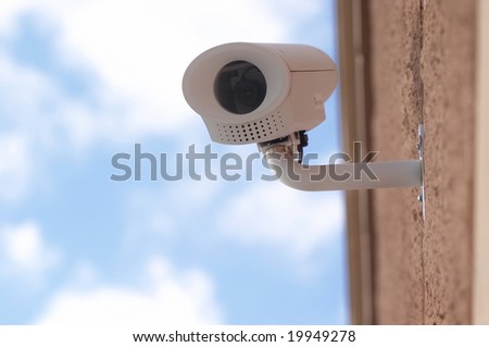 Security surveillance camera on side of building