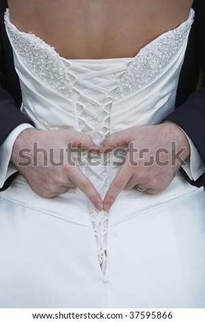 Heart shape hands of groom around bride at wedding