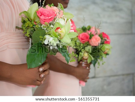 Wedding bouquets in hands of African American bridesmaids at ceremony