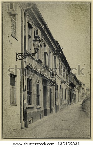 Street with old houses of the old town of Petrovaradin, near Novi Sad in Serbia. Black and white image stylized as vintage postcard.